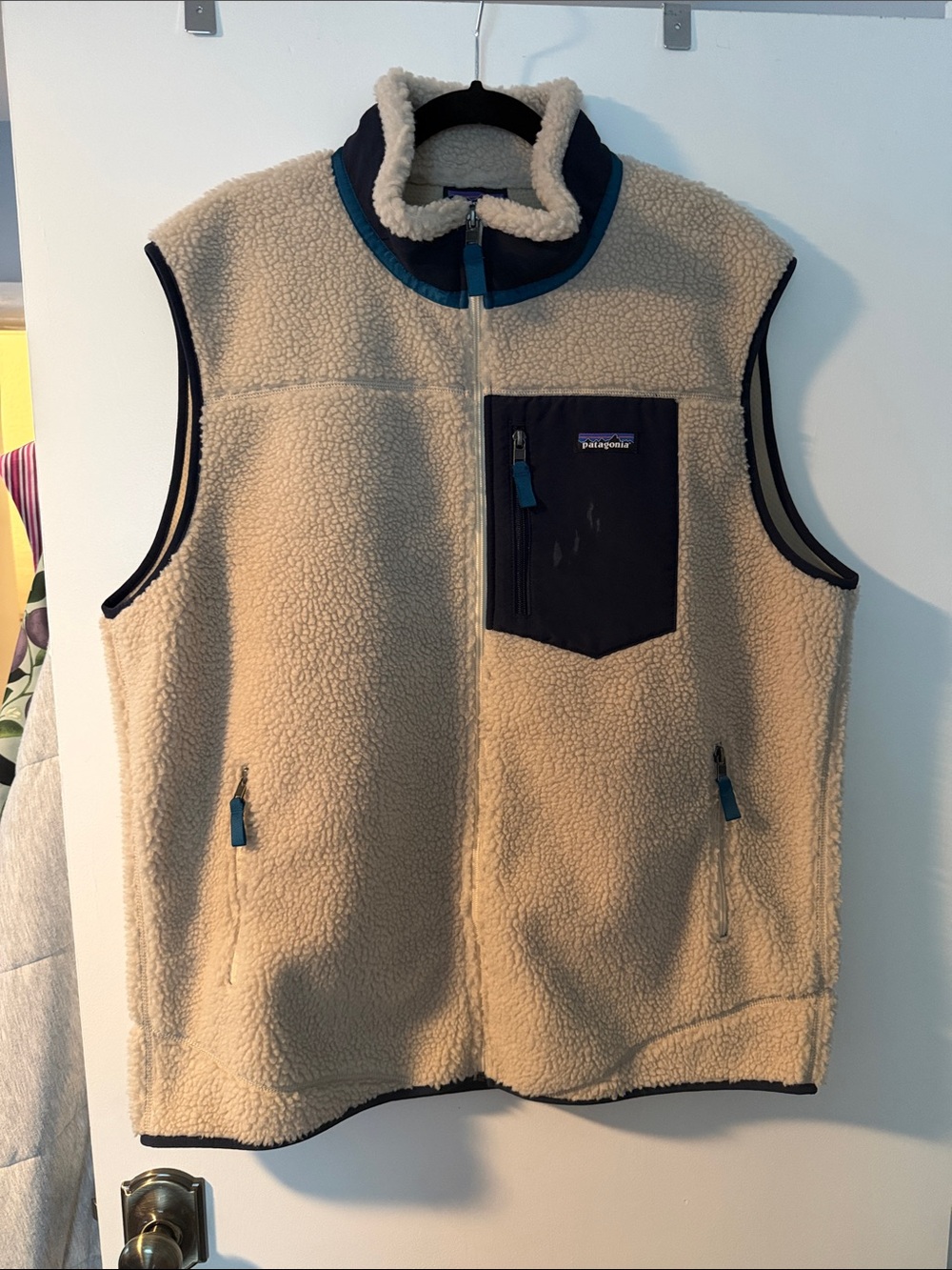 Patagonia Cream Sherpa Vest with Navy Chest Pocket and Teal Trim